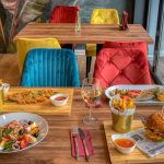 Colorful dining setup in a modern restaurant featuring diverse meals and vivid decor.