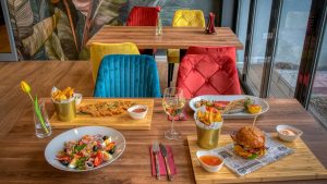 Colorful dining setup in a modern restaurant featuring diverse meals and vivid decor.